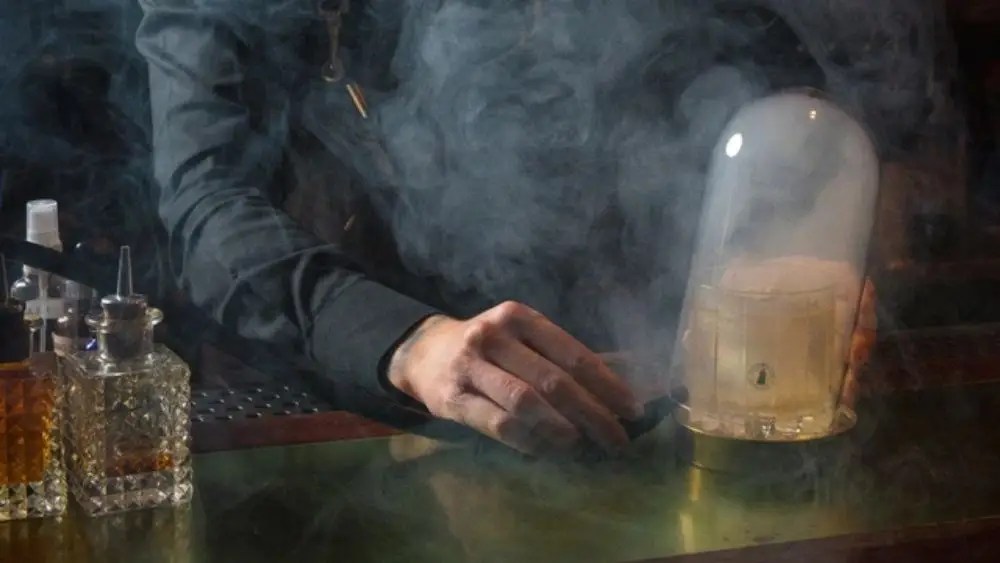 Cocktail at White Oaks Saloon served under a glass dome filled with smoke.
