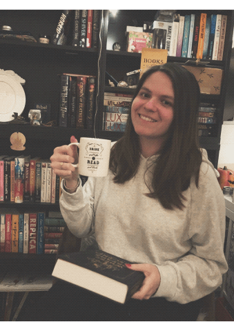 girl cheers with mug, takes sip and opens book gif