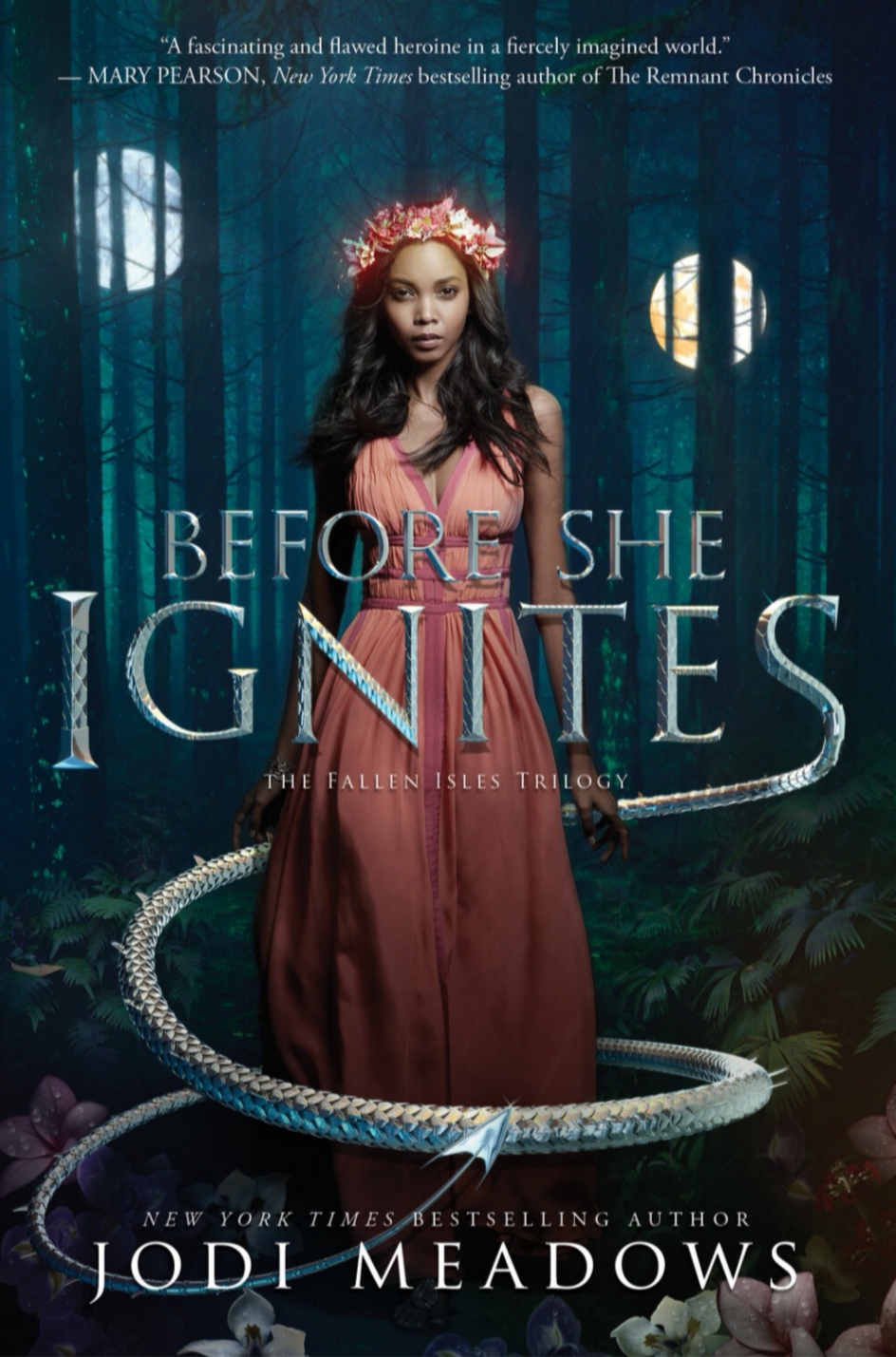 The book cover of Before She Ignites by Jodi Meadows: a black woman, dressed in a long pink dress, standing in the woods
