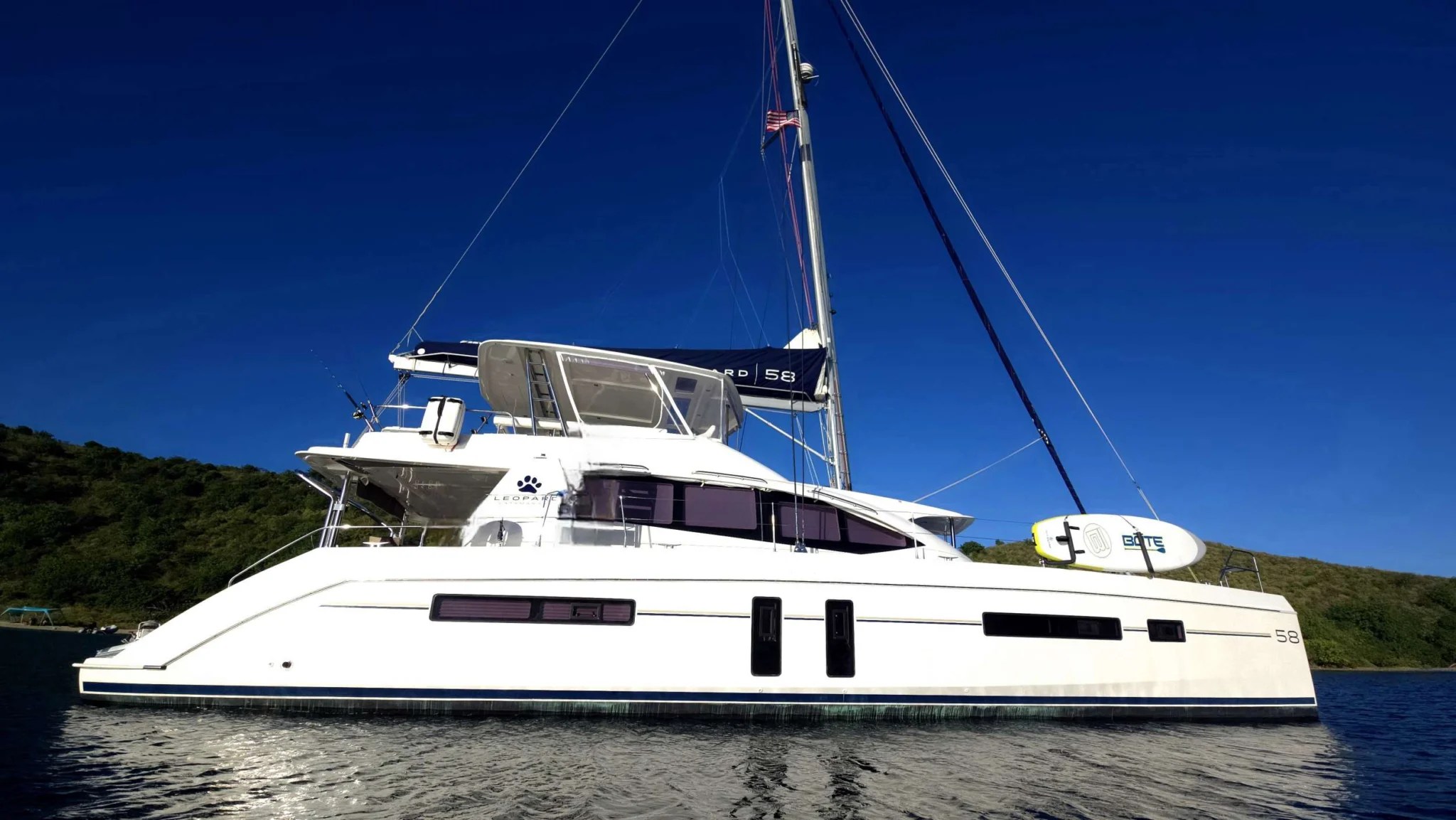 RUBY ONE yacht – Welcome to Ruby One, A beautiful 58-foot sailing catamaran features two spacious queen- suites, and a spacious Mater Suite with a lit dressing table and double vanity.  All cabins are suited with AC, table fans and Flat screen TV.  All cabins are fitted with bamboo linen, providing cool, comfortable sleeping.  Our extra-large main deck salon has large windows all around providing great lighting, breezes and amazing views of the ocean.  The salon is fronted by a private forward lounging cockpit, great for your morning coffee.
Our large flybridge is a perfect spot to gather for appetizers and drinks with family and friends watching the sun set.  The Fly bridge is also equipped with sounds for dancing under the stars.  
Enjoy dining either in the salon, or al- fresco on the aft deck.
Guests can explore the ocean with our new ScubaPro snorkeling gear, Subnados (under water scooters), Lift 5 E-Foil, kayaks, paddleboards, tubing, water skis and fishing gear or unwind on our Bote 360 Floating dock drifting in clear blue waters.
Ruby one is equipped with Bluetooth Bose Surround sound system, salon Flat Screen TV, board and card games, or pick up the Captains acoustic guitar and strum a few tunes.
Come join us for a perfect escape in the beautiful British Virgin Islands!