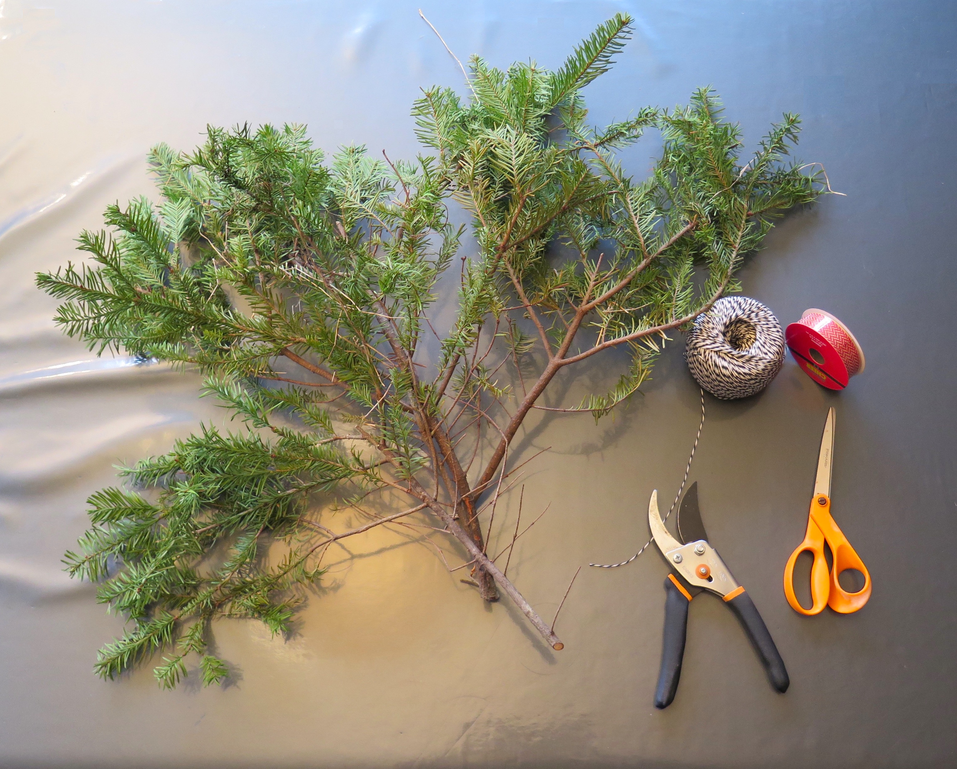 Fir tree branches, ribbon, string, scissors, pruning shears.