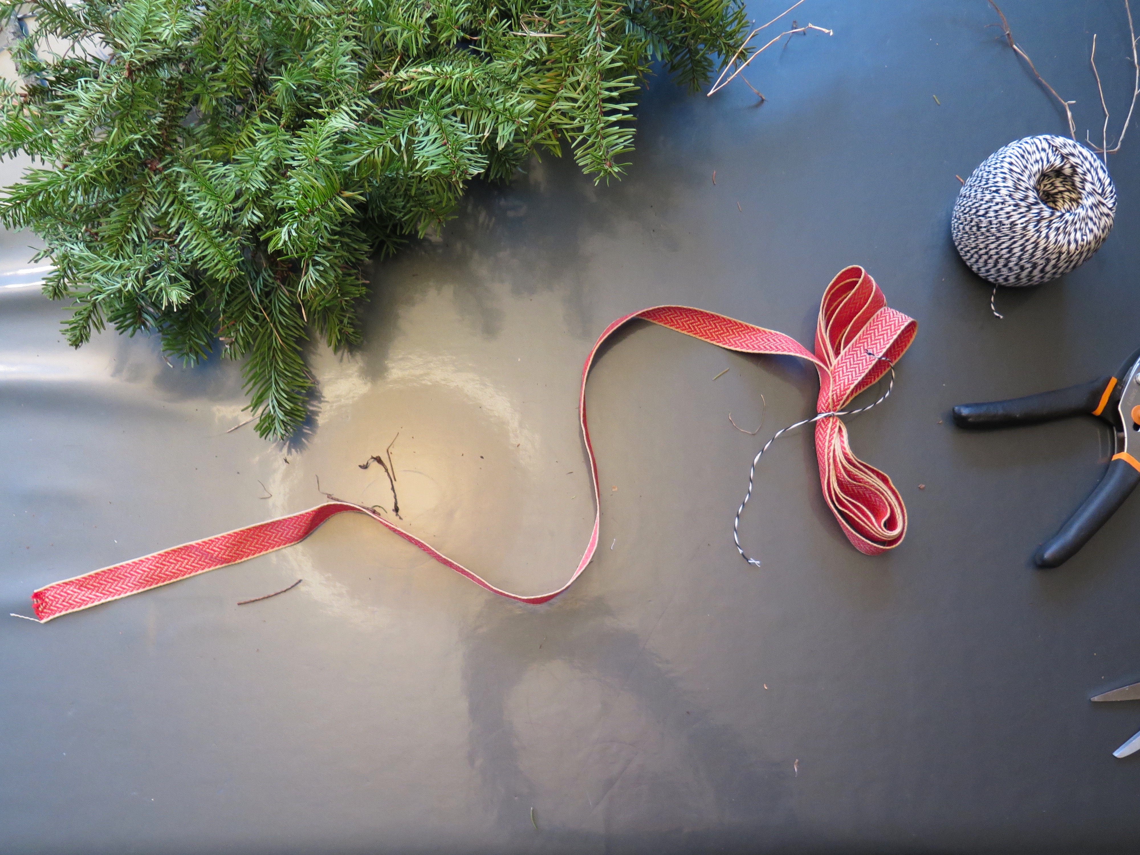 Make a ribbon bow. Begin by looping the ribbon and tying it in the center with string.