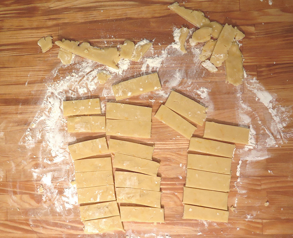 Cutting shortbread into rectangles and trimming the edges.