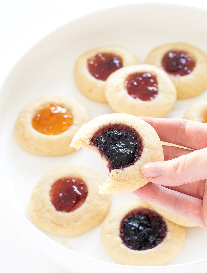 thumbprint cookies filled with different flavors of jam, arrange on a white plate