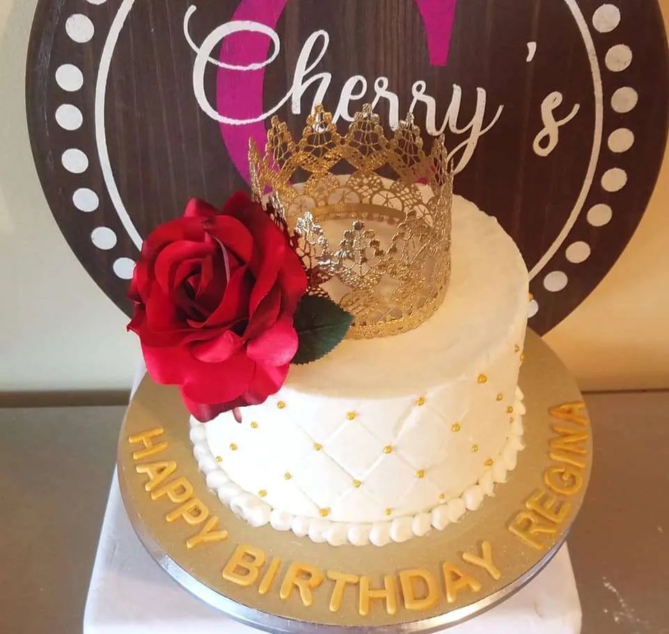 cake with gold grown and red rose