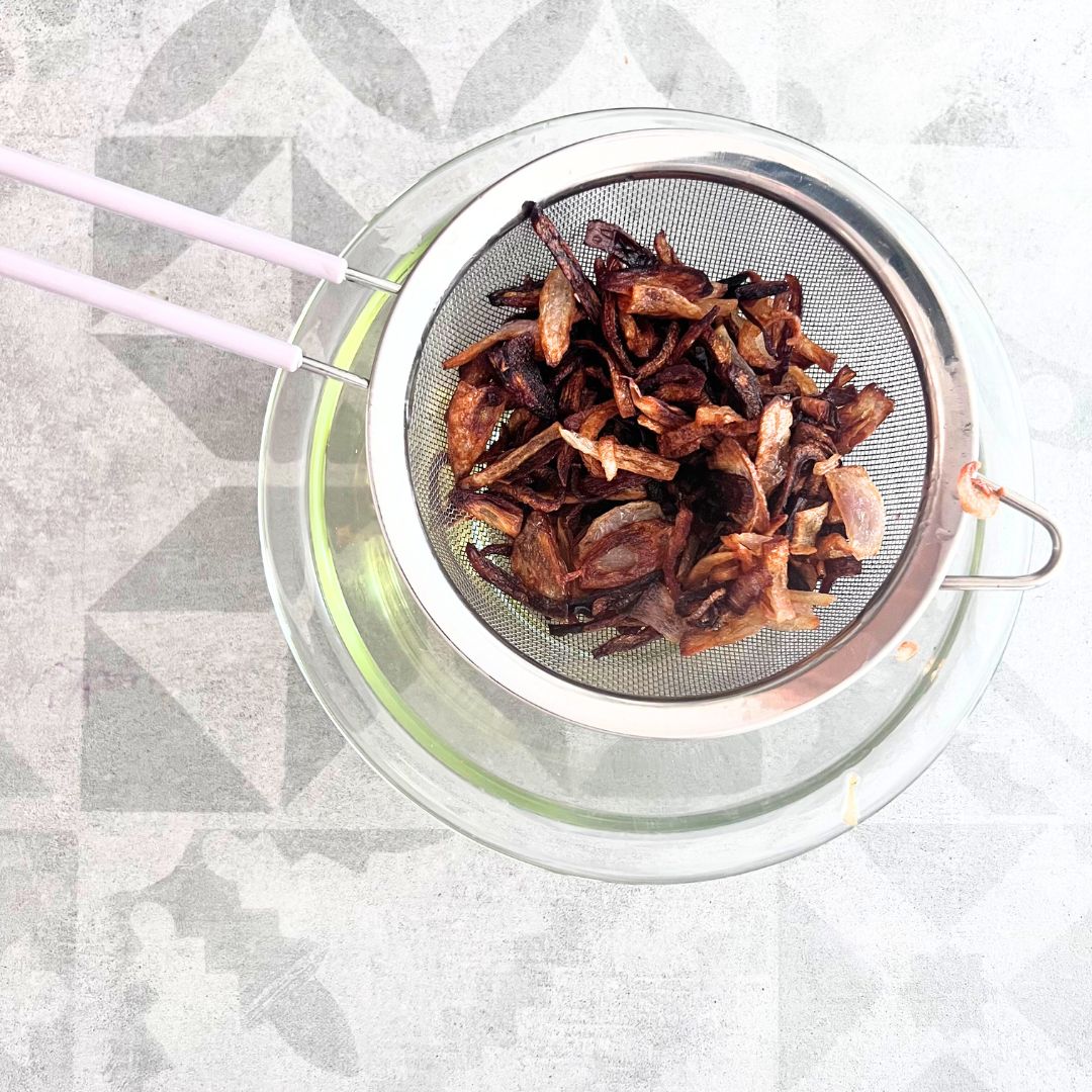 Filter the frying oil using a strainer.