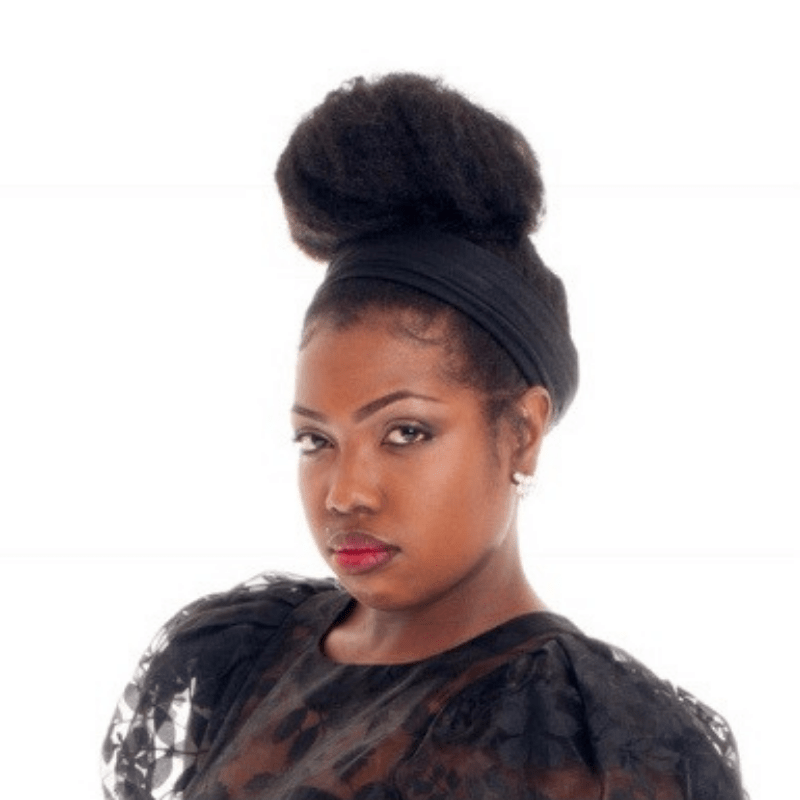A dancemaker with a black blouse, red lipstick, and black hair in a high bun faces the camera.