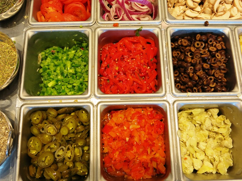 Colorful array of fresh vegetables and cheeses for pizza