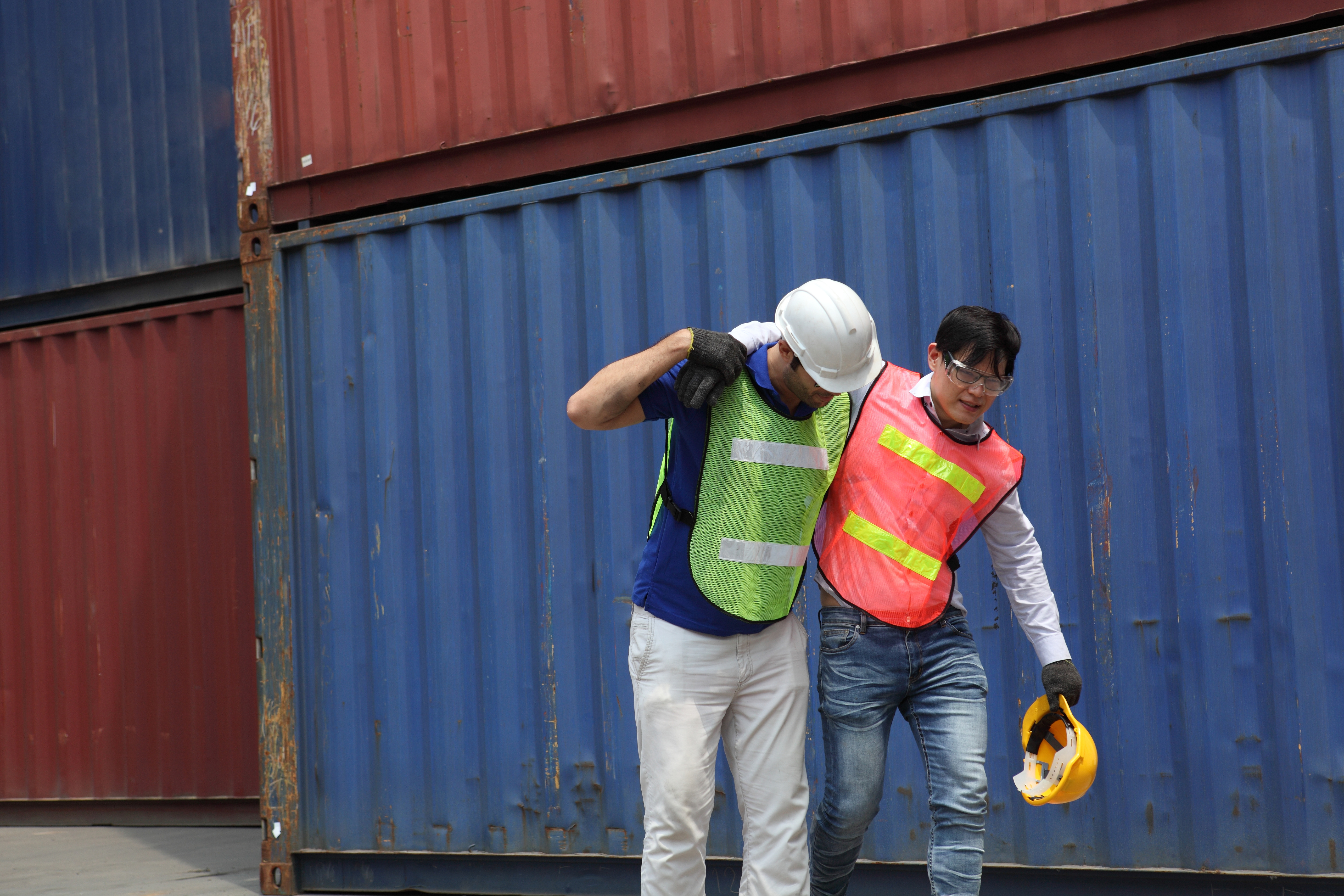 Man assisted by colleague by containers.