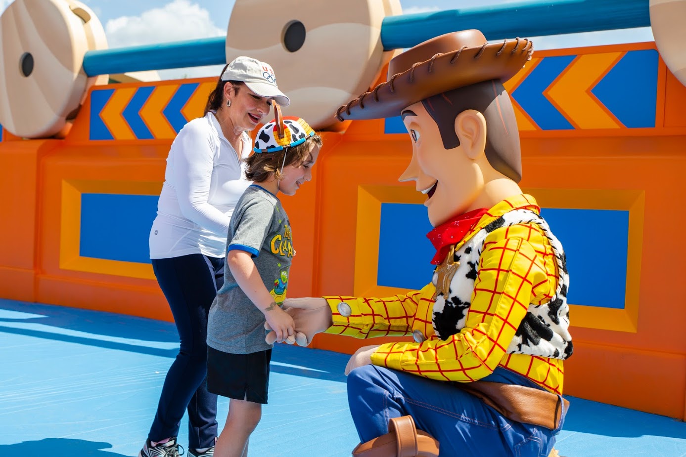 Gloria Estefan watches as her grandson, Sasha, shares a special moment with Woody, Sunday, June 24, 2018, while previewing Toy Story Land at Disney's Hollywood Studios in Lake Buena Vista, Fla. In the new land, officially open on June 30, Walt Disney World Resort guests can whoosh along on the family-friendly roller coaster Slinky Dog Dash, take a spin aboard Alien Swirling Saucers and try for the high score on Toy Story Mania! (Steven Diaz, photographer)