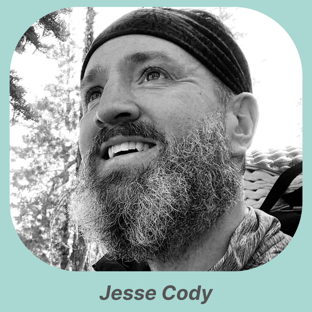 Black and white image of bearded man wearing hat and smiling