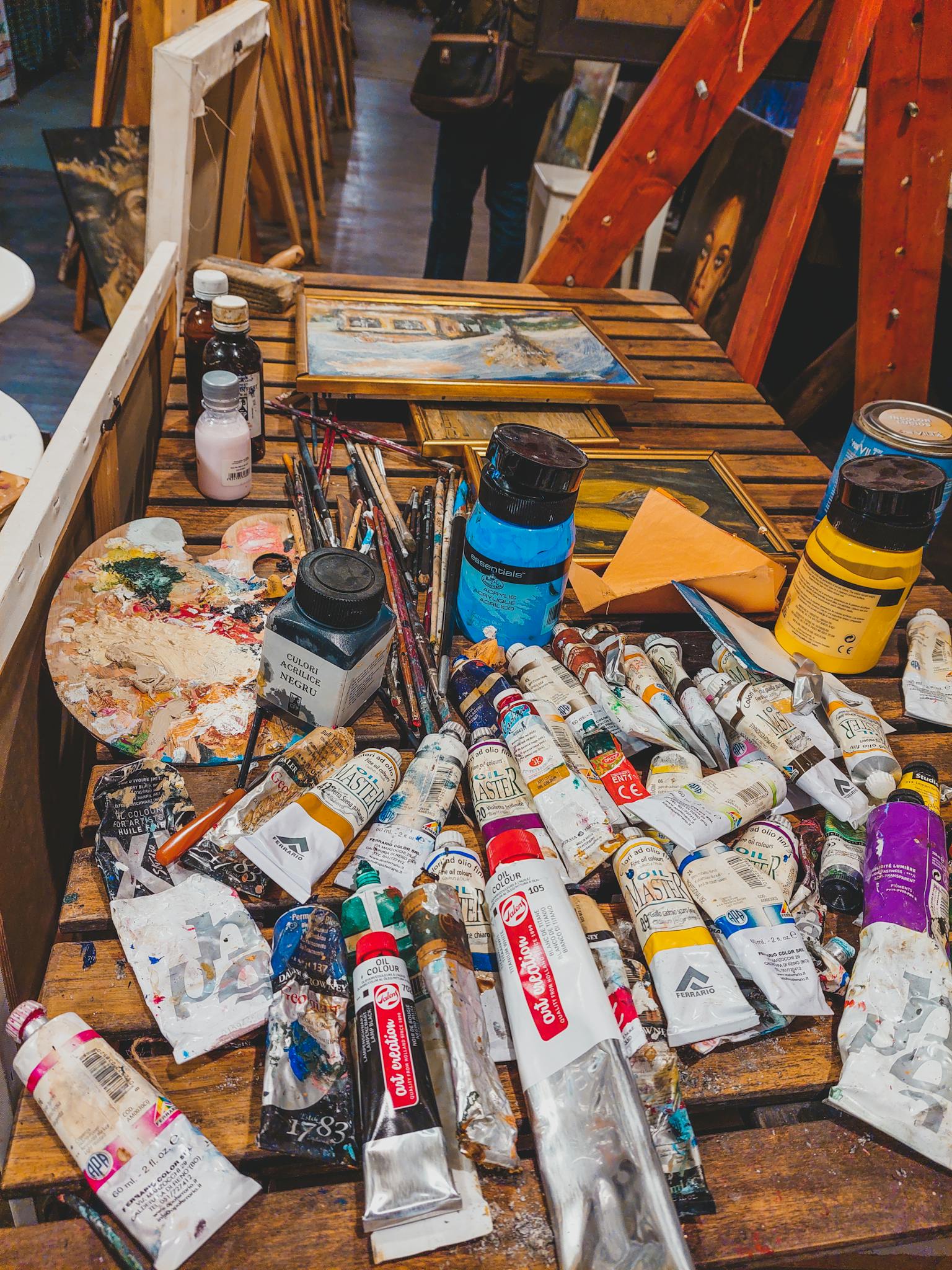 A table with paint, brushes and other art supplies
