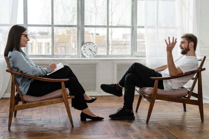 pexels-photo-4101143-3 person in black pants and black shoes sitting on brown wooden chair