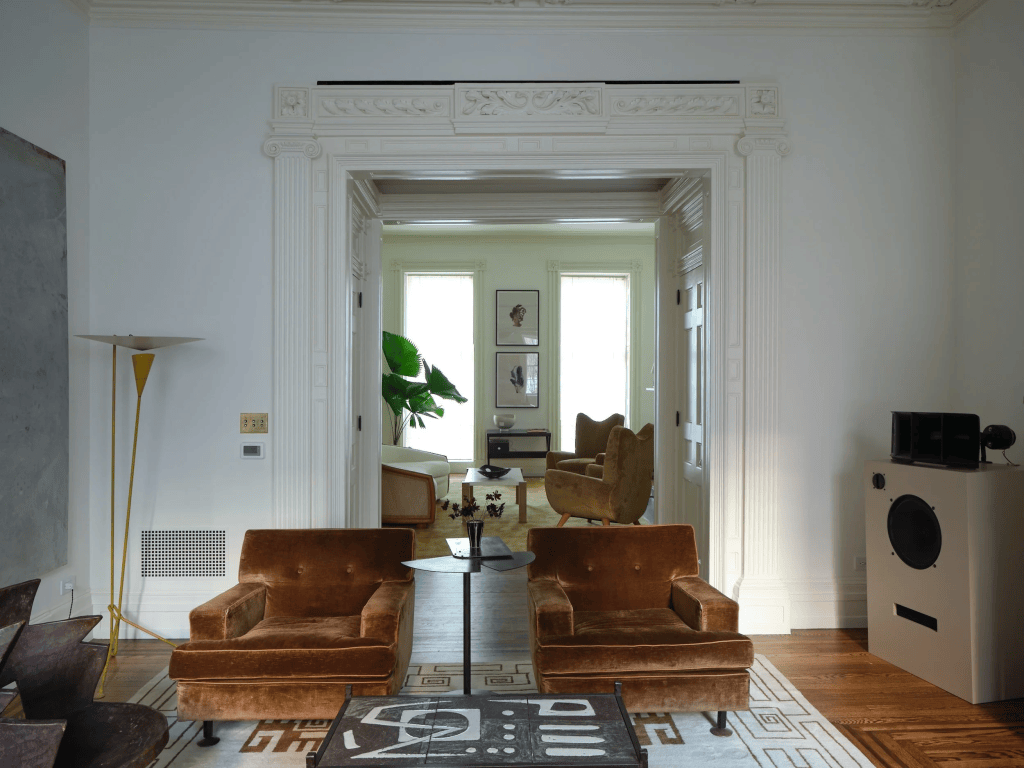 Sitting on an Ivan de Silva Bruins rug with Aztec motifs—a Beauvais reproduction—the oxidized-metal fan table is a Galerie MCDE edition of Pierre Chareau’s design for the Maison de Vere in Paris, 1929.