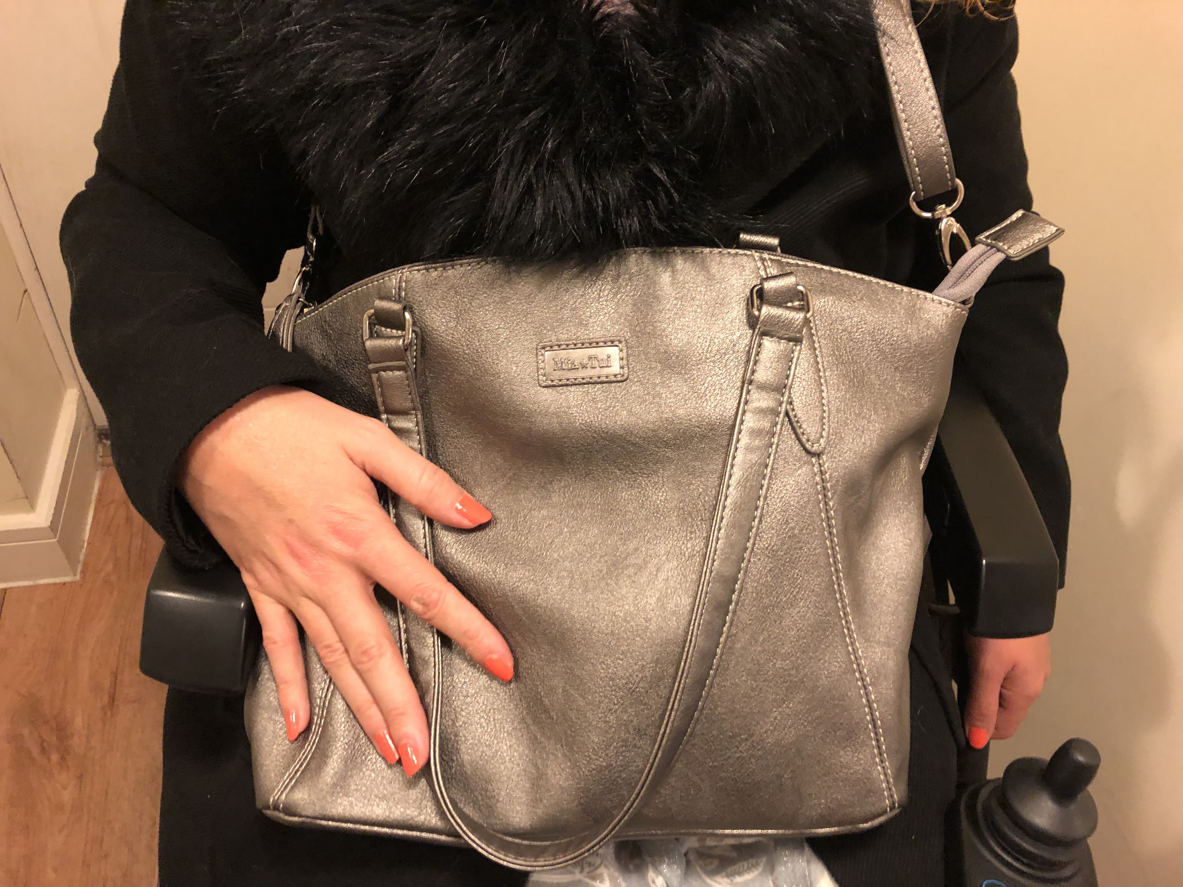 Carrie holds the Mia Tui handbag in metalic grey.