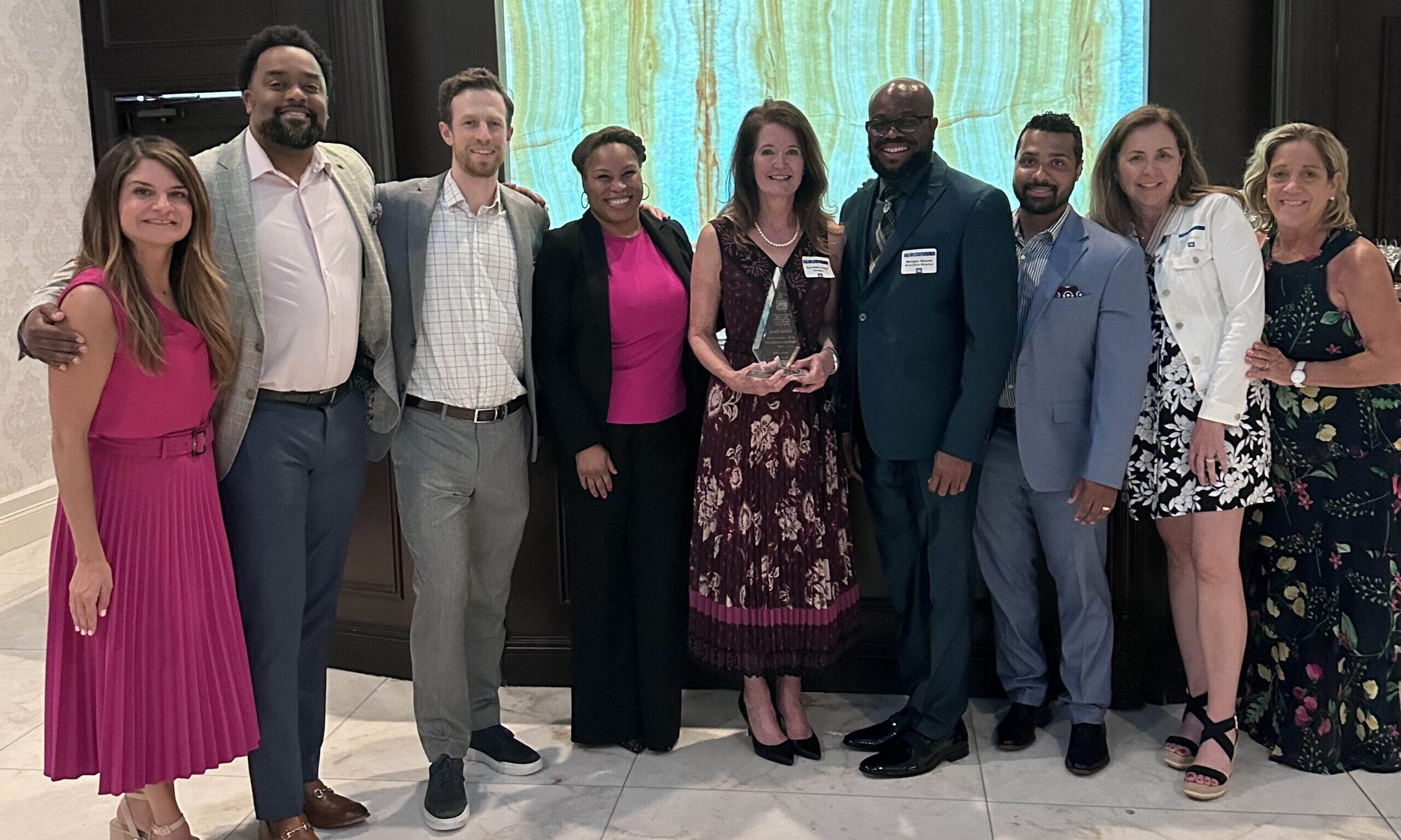Corinne holding the Community Award surrounded by Cinnaire staff at Sojourners' gala