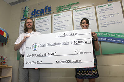 Kushindokai Karate and Fitness owner and head instructor Michael Fisher presents a cheque for $10,008.75 to Dufferin Child and Family Services Executive Director Jennifer Moore.