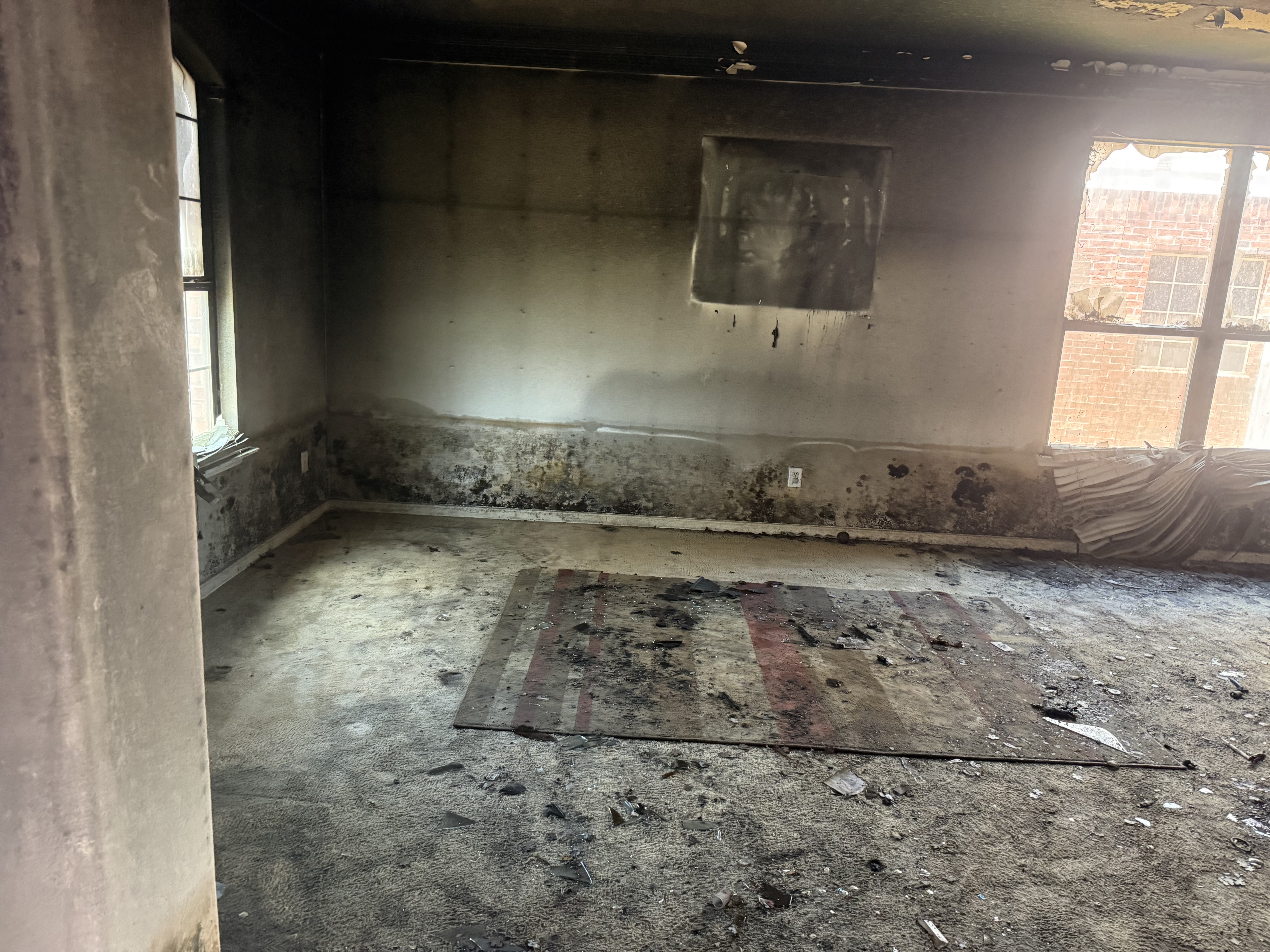 Fire damaged room with charred walls and ceiling before a fire damage cleanout by CJ's Junk Removal