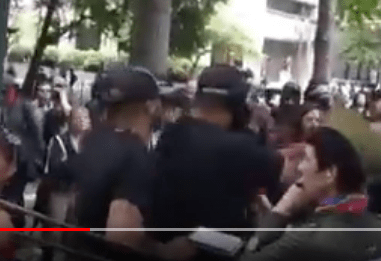 Tiny puts his hands out first, and shoves the person backwards, into a crowd of bystanders.