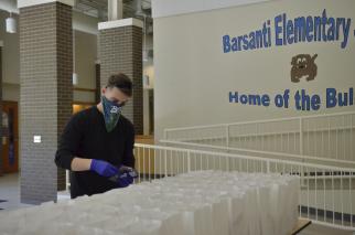 FTC Child Nutrition Specialist Matthew Dove, vice president of the Fort Campbell BOSS program, helps package free grab-and-go breakfast and lunch meals for children ages 18 and younger, April 16, at Barsanti Elementary School. The free food distribution is part of the Fort Campbell Child Nutrition Program. (Emily LaForme, Fort Campbell Courier)