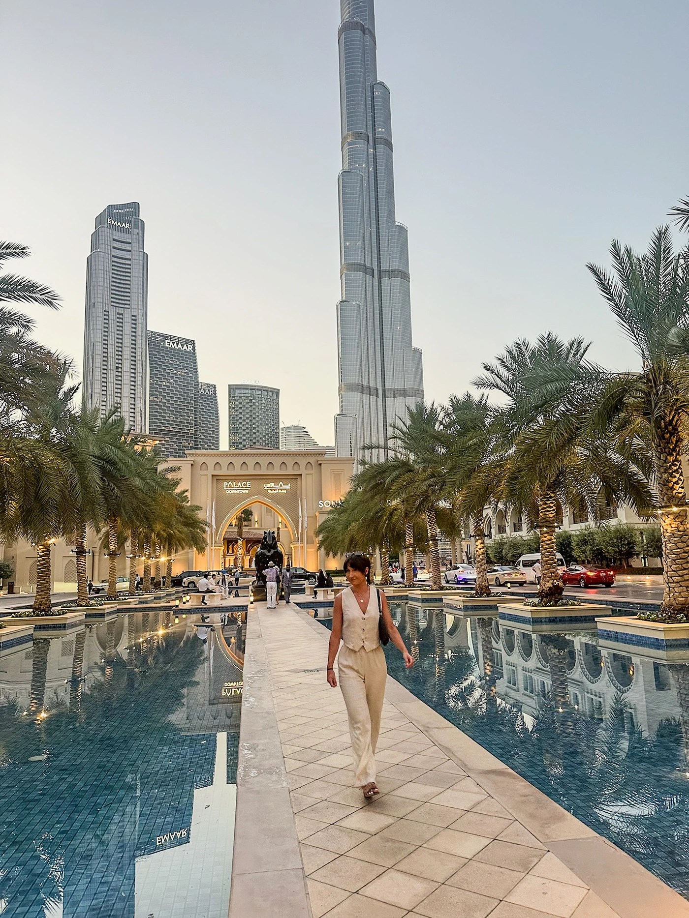 A girl in a linen co-ord walking in front of the Dubai Mall and Burj Khalifa