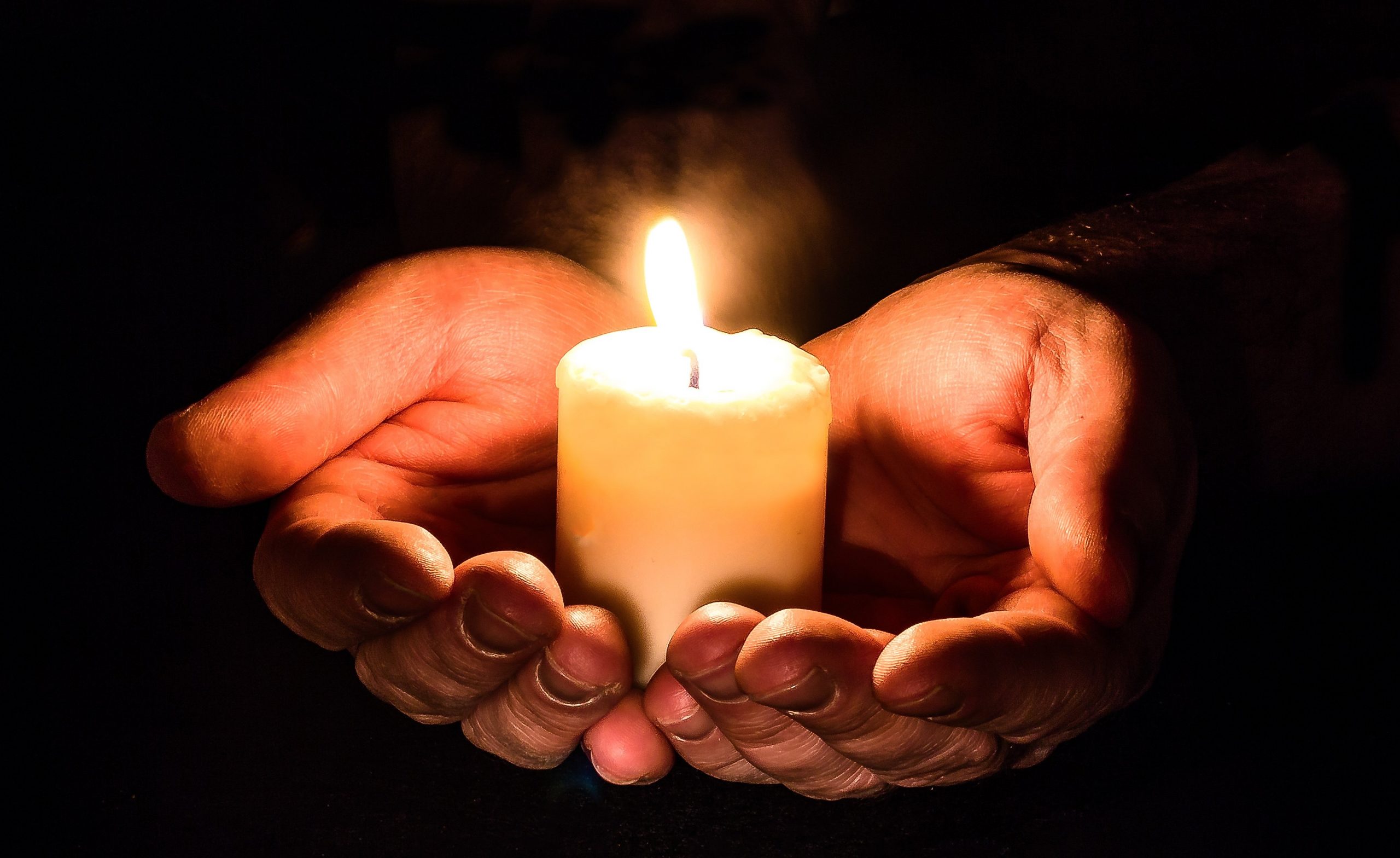 candle protected by hands