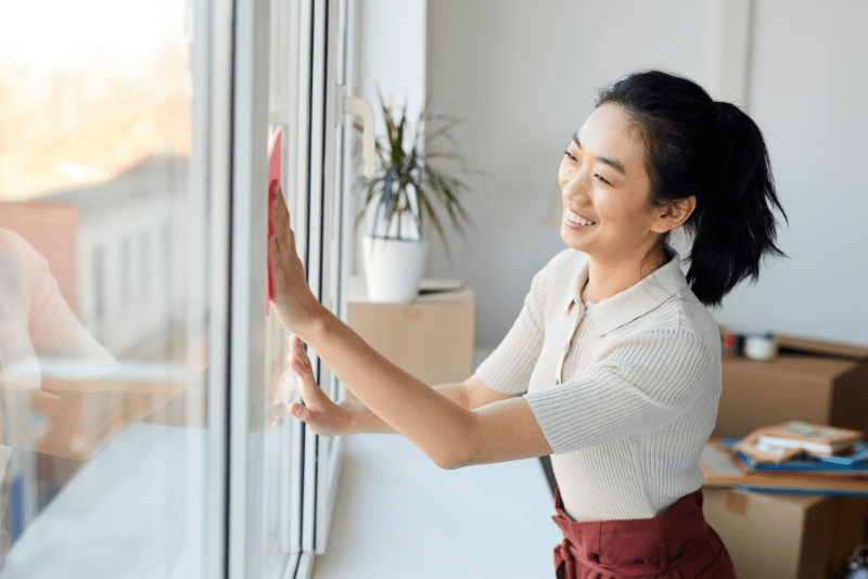 woman wiping windows with a cloth