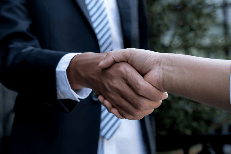 Two people shaking hands to close an agreement