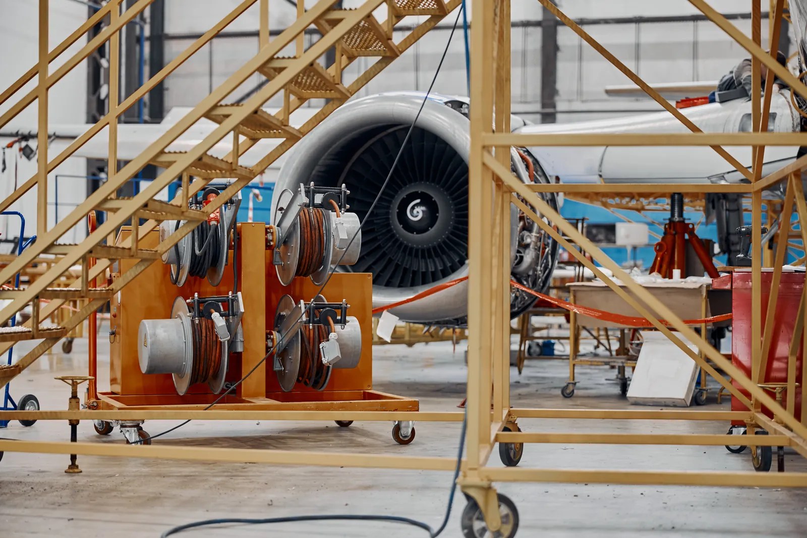 Aircraft engine under maintenance with access platforms in a large hangar