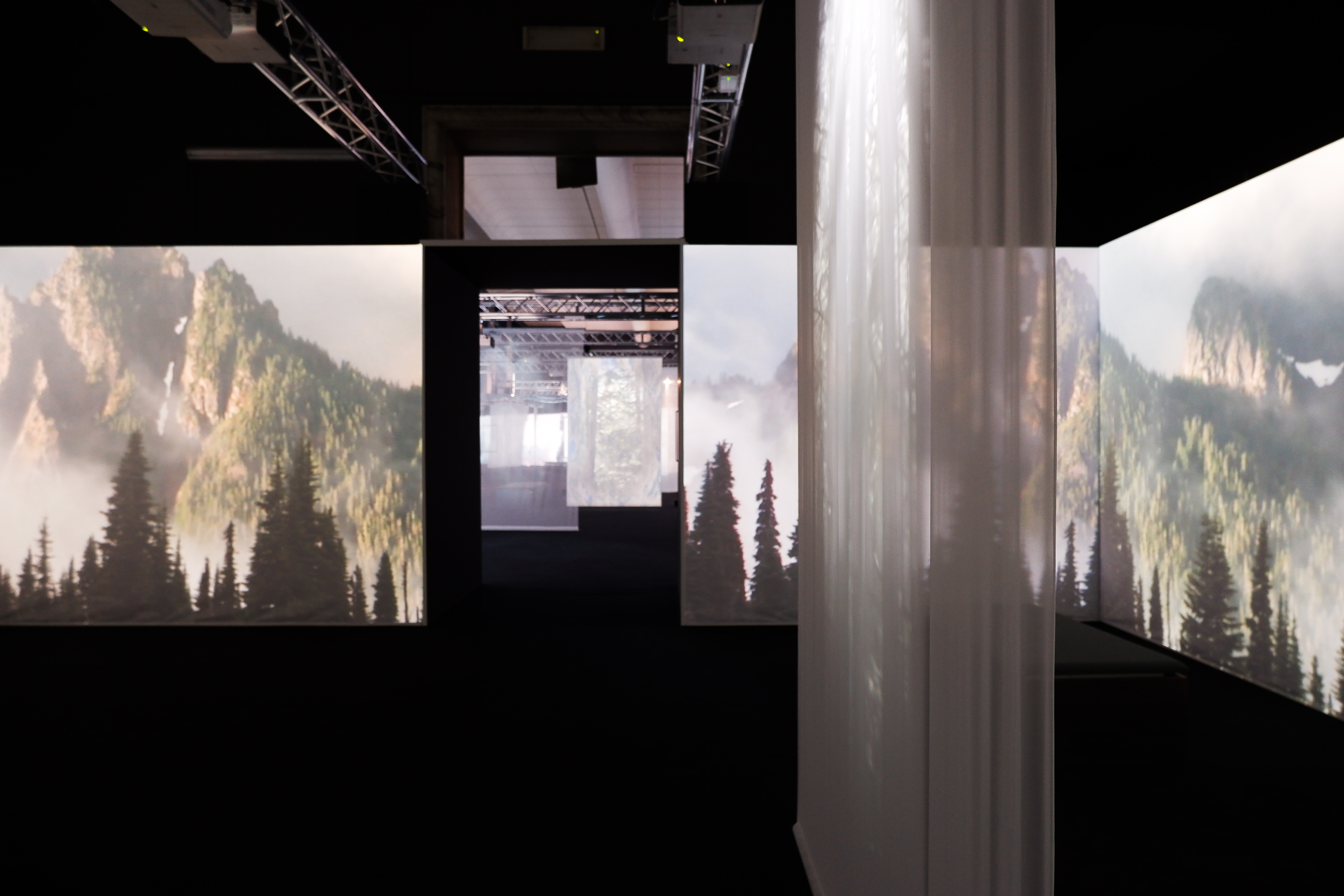 Prima sala con schermi che proiettano immagini di paesaggi naturalistici.