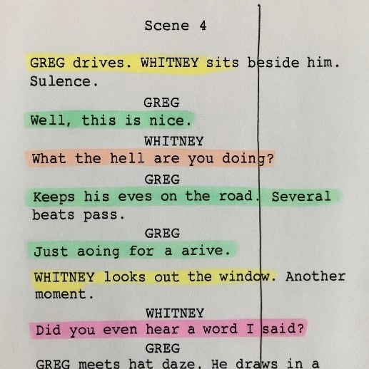 A photograph of a printed script page with various colored highlighter marks and a vertical line drawn through a scene.
