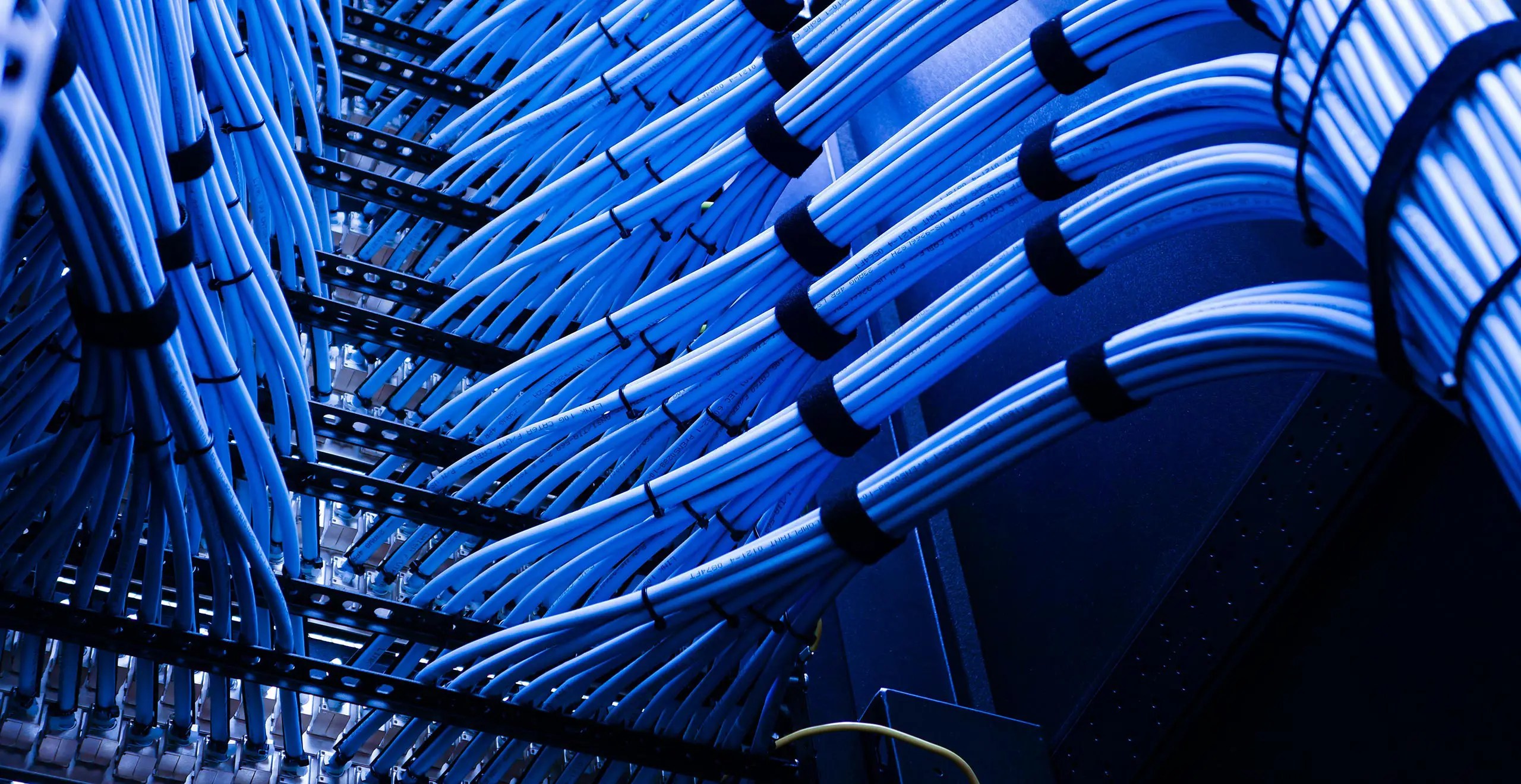 A high-density rack of enterprise servers in a dark data center, illuminated by sharp blue LED status lights, representing AI infrastructure.
