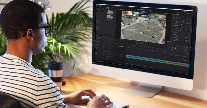 Homem usando o DaVinci Resolve na tela do computador para ver um artigo sobre como reverter um clipe no DaVinci Resolve.