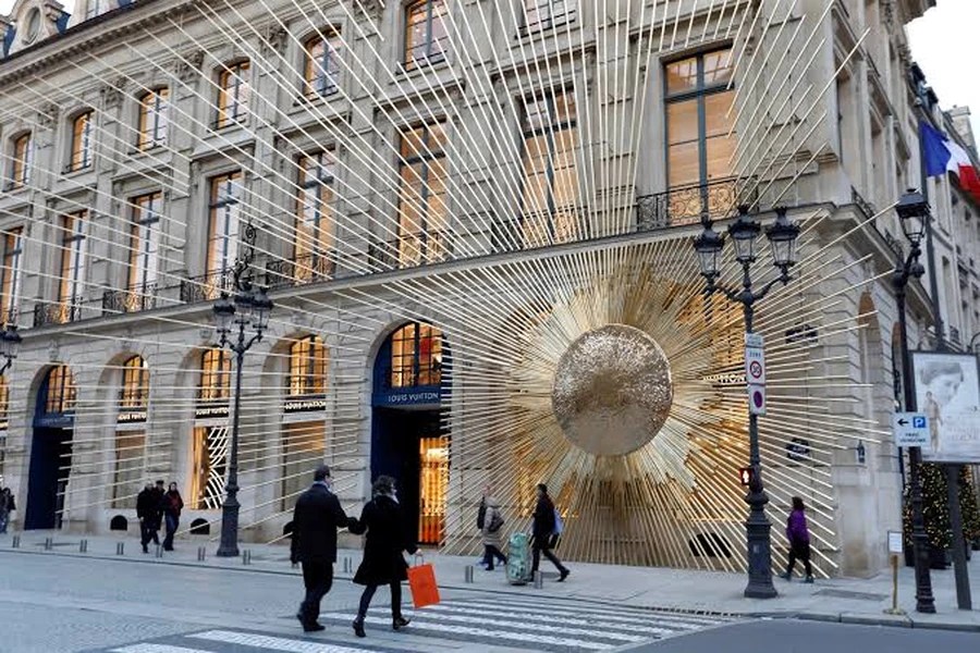 Fachada de Louis Vuitton en París con escultura dorada en forma de sol radiante