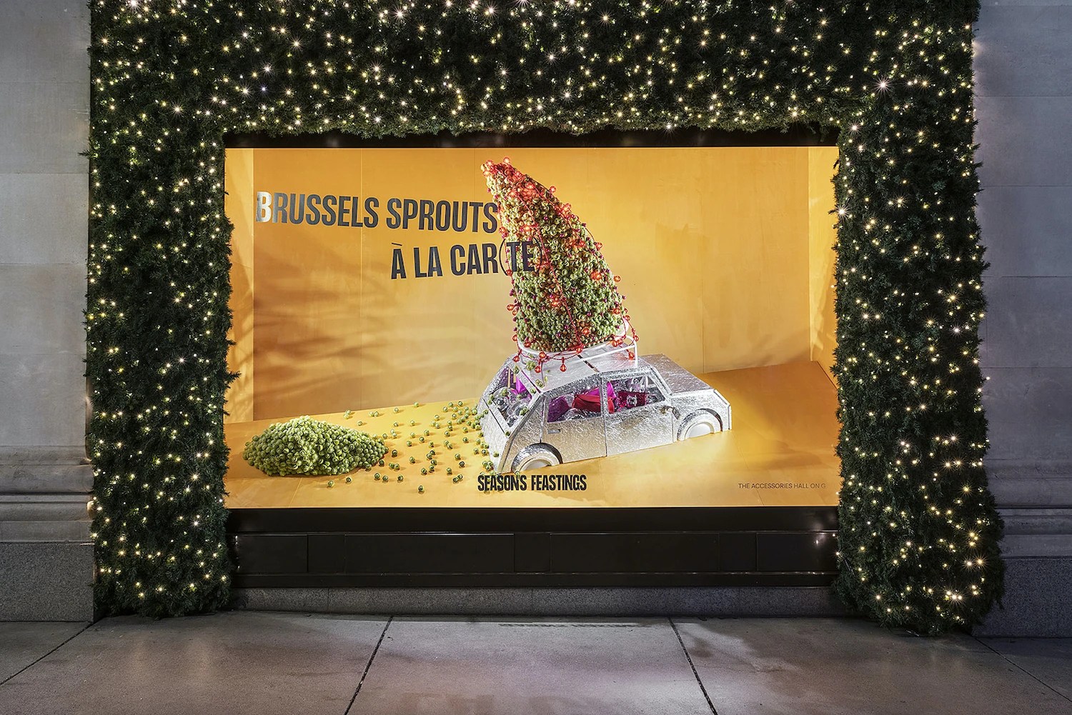 Escaparate navideño con guirnaldas de luces, coche en miniatura y coles de Bruselas