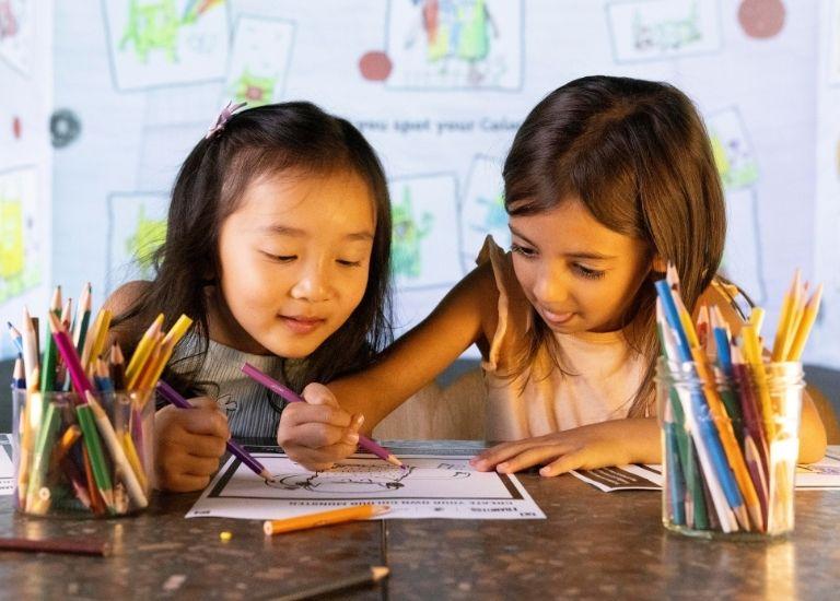 Two children colouring The Colour Monster activity sheets in the Blank Canvas Gallery at FRAMELESS