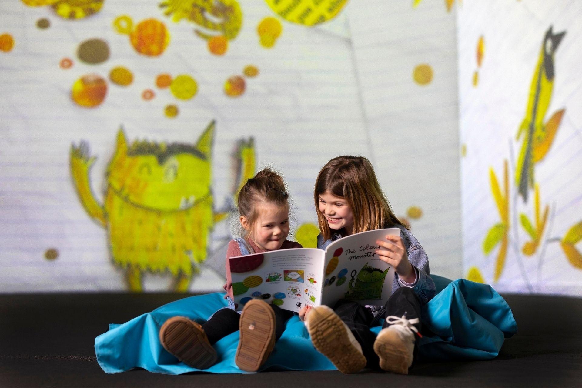 Two children reading the Colour Monster at FRAMELESS