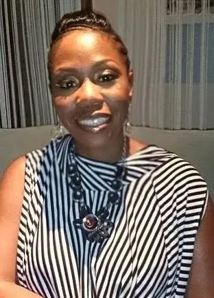 Shot of Tara Walker wearing black and white sleeveless blouse and a neckless with gems.