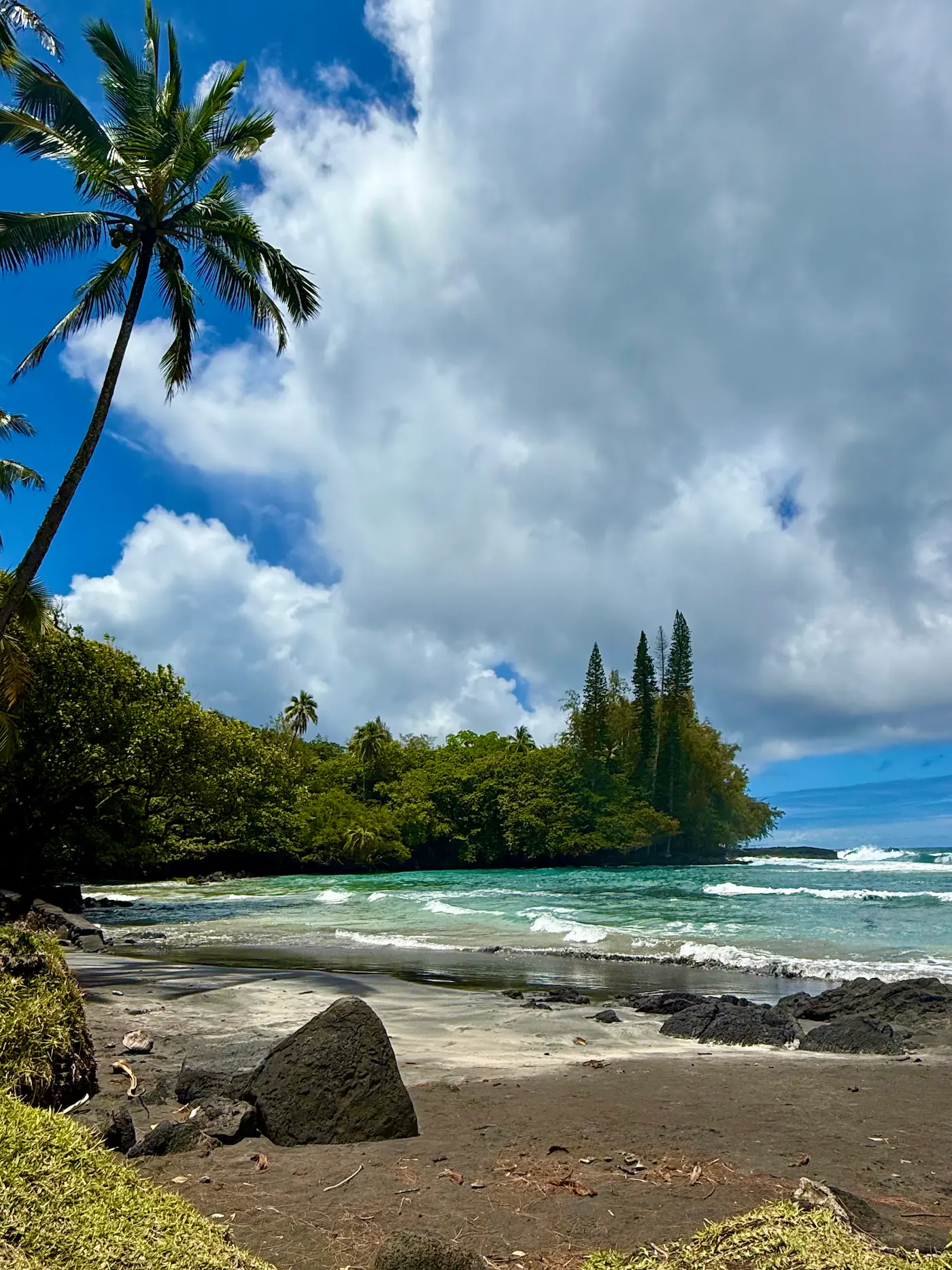 view of the cove at Shipman's Beach with black sand beach in Hawaii, part of Shipman's estate 