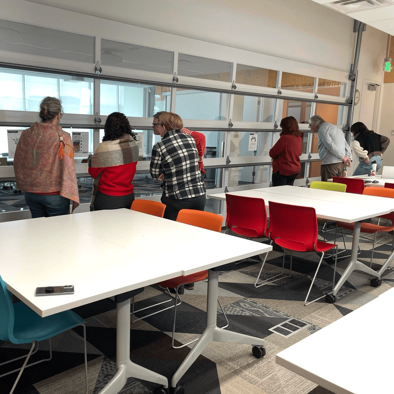 6 people looking at illustrations on the wall