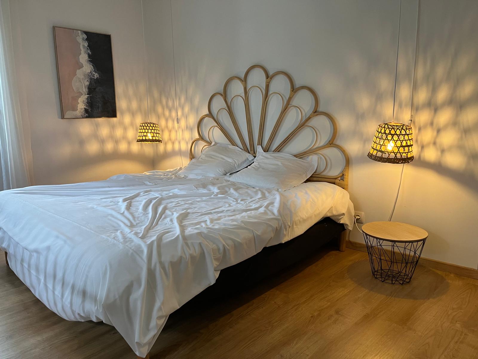 Chambre avec lit double, table de chevet et lumière naturelle dans le mas