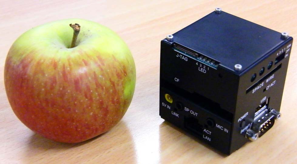 O Space Cube xunto a unha mazá para deixar constancia gráfica do seu reducido tamaño