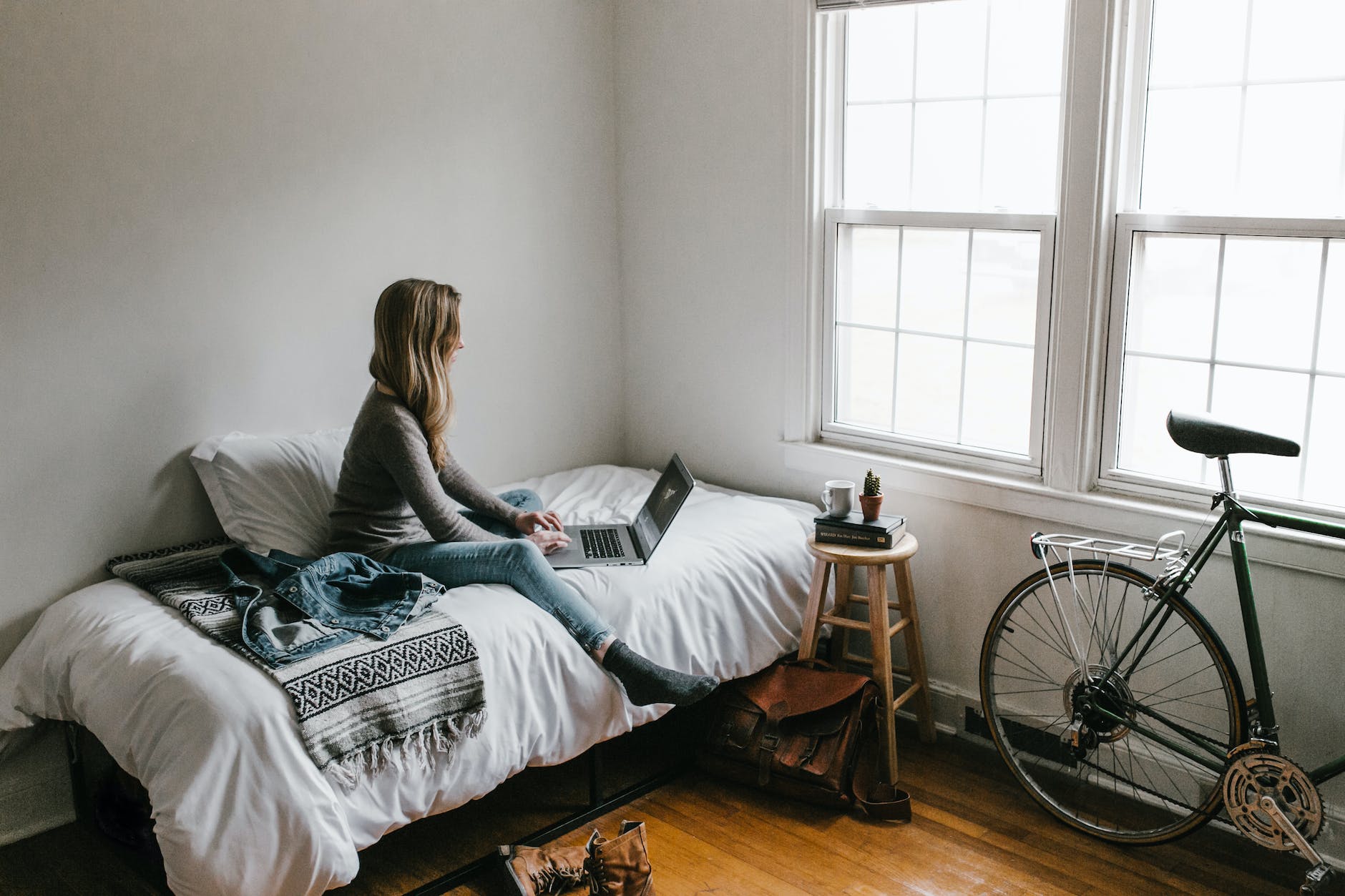 woman in gray shirt sitting on bed