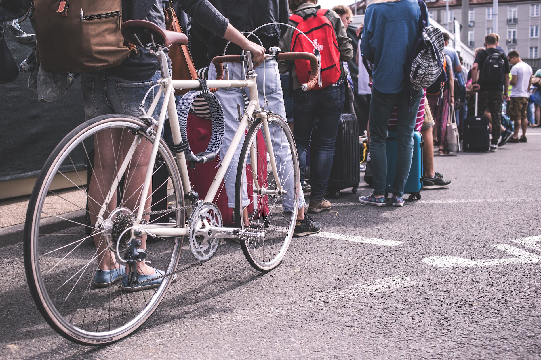 person in black sweater hold a grey road bike