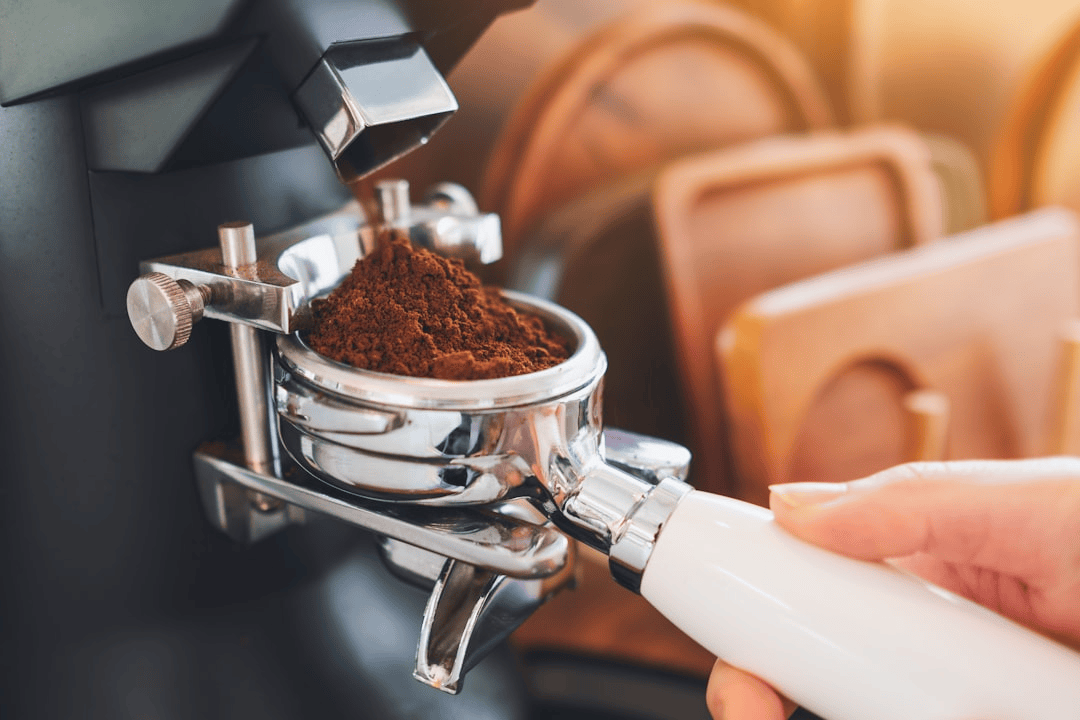 Single dose grinder dispensing coffee grounds into a portafilter