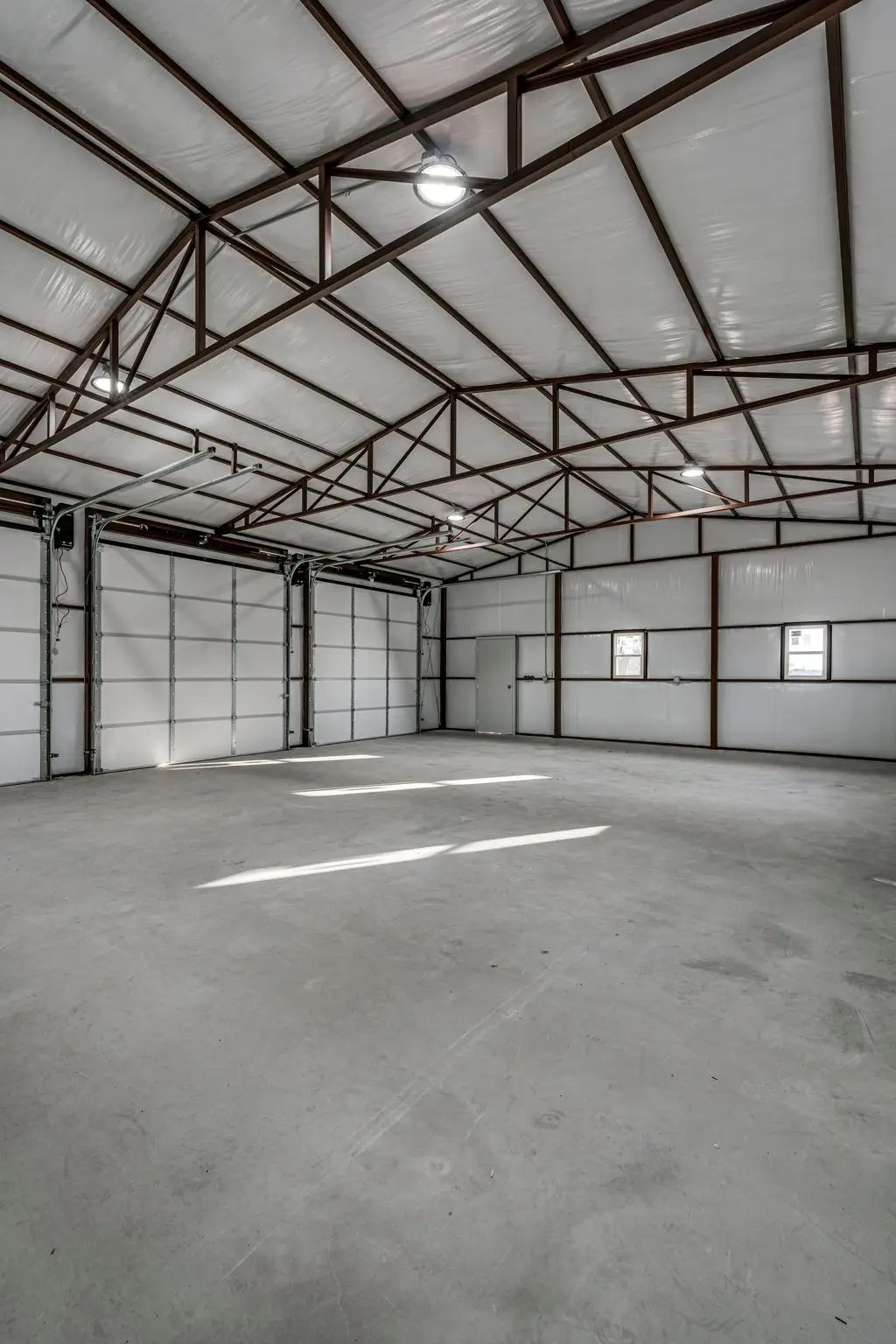 Interior of a completed metal building workshop showing exposed steel-truss framing by Cogburn Contracting
