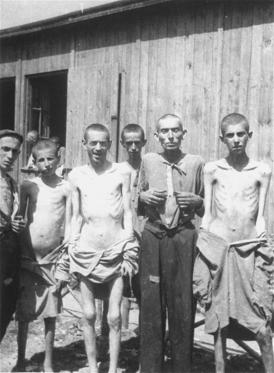 #1 barnes jewish hospital plaza, service building, suite 230. A group of survivors pose in front of a barracks in the