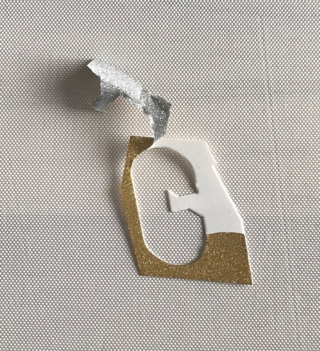 Photo of a piece of Recollections gold glitter card stock that peels right off the backer. 