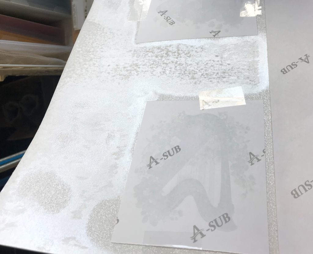 Photo of a piece of white glitter card from Recollection that was melted in the HTVRont heat press when attempting to sublimate.