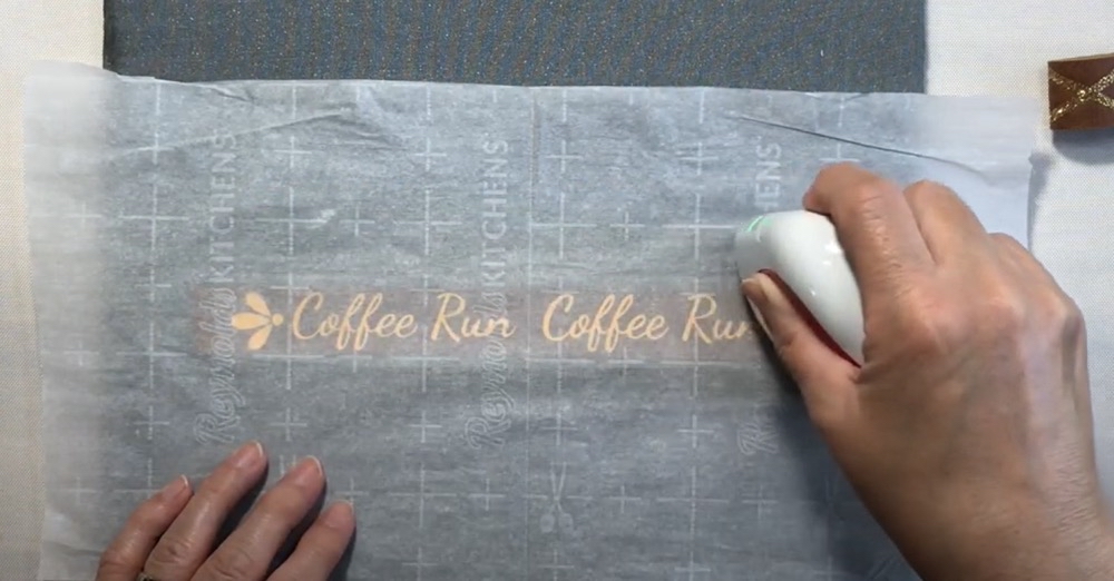 Photo showing the process of heating the Siser EasyWeed HTV with the Cricut Mini EasyPress and parchment paper. 